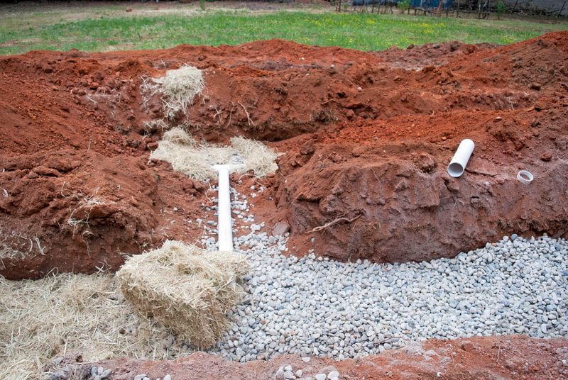 Rough and Ready, CA Rock and Hay for Septic System Installation Leach lies dug and laid with white septic pipe.