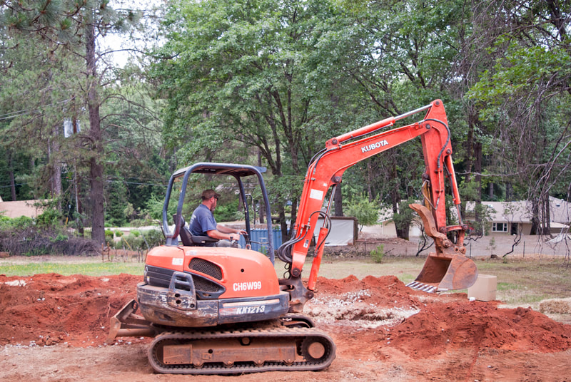 Grass Valley, CA Residential Excavation for Septic System Installation, guy driving tractor digging leach lines