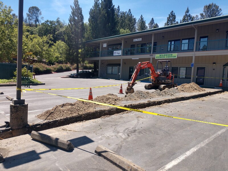 Lake Wildwood Business Center, Penn Valley CA Upgrading Main Water Line with excavator, digging up the parking lot